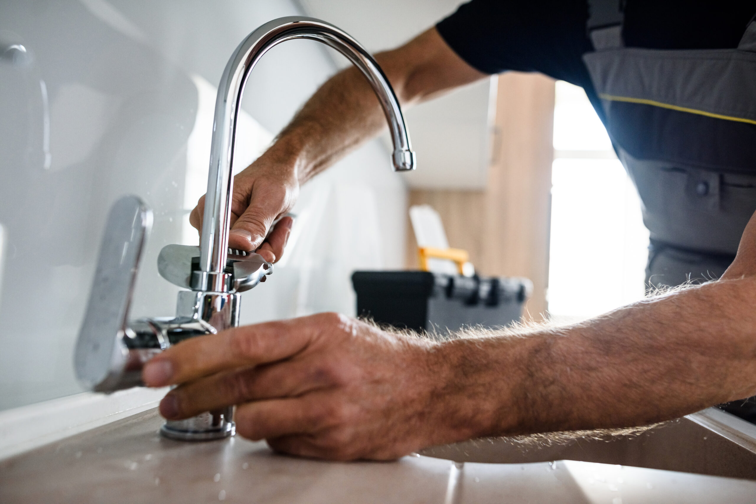 Plumber repairing a kitchen faucet